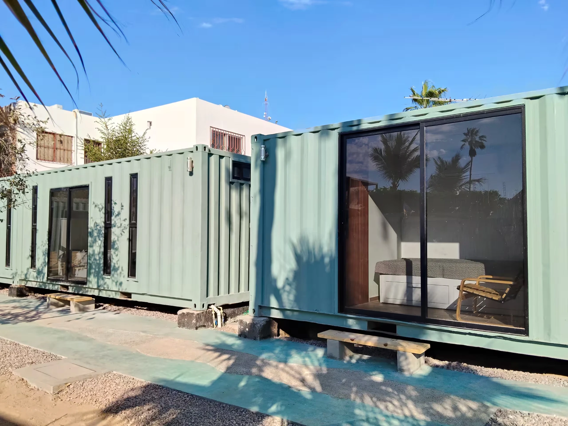 Espacios tipo contenedor con ventanal y banca de madera en Villa Ballena, La Paz, BCS